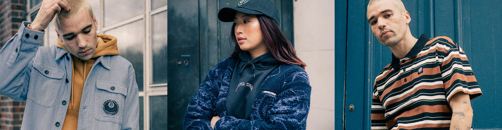 Three models wearing Santa Cruz Clothing, including a light blue denim jacket with a yellow hoodie, a dark blue textured denim jacket with a black cap, and a brown and black striped polo shirt, set against a split background of gray brick and dark blue metal doors.