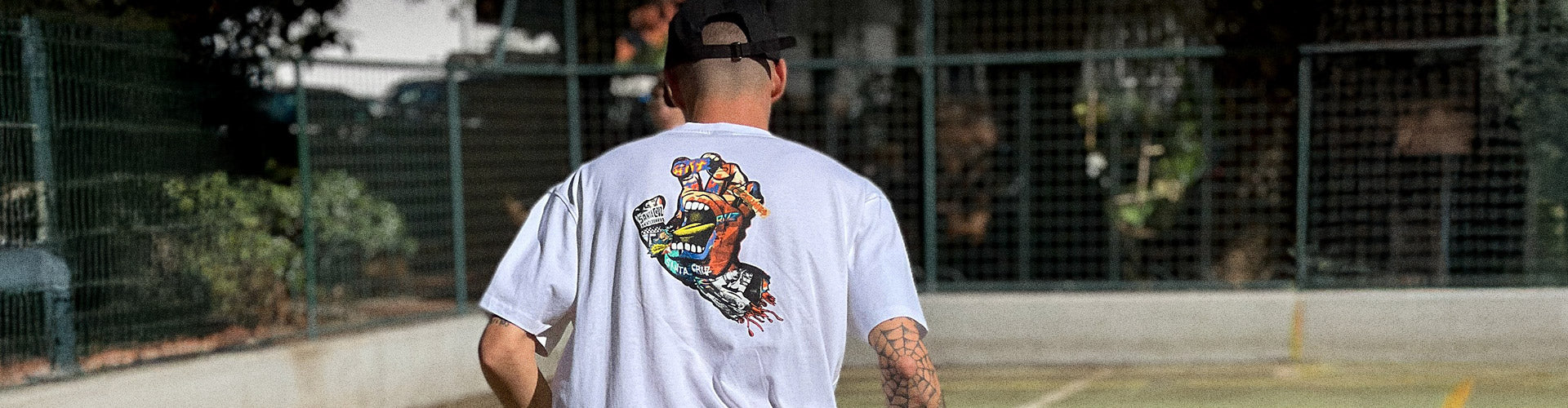 Santa Cruz Ad Collage Graphic Collection. Man wearing a white Santa Cruz t-shirt featuring a colorful graphic of a screaming hand.
