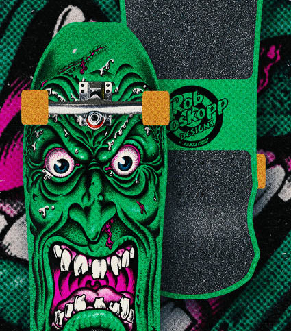 Santa Cruz Skateboard with a green face design on a colorful background.